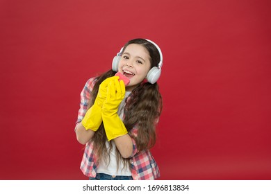 Make Household More Joyful. Harmless Cleaners Using Simple Ingredients. Cleaning Party. Girl Wear Headphones And Protective Gloves For Cleaning. Listening Music And Cleaning House. Having Fun.