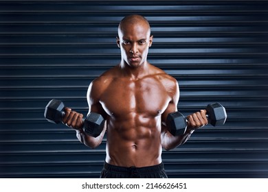 Make Persistence A Habit. Shot Of A Sporty Young Man Working Out With Dumbbells As Part Of His Exercise Routine.