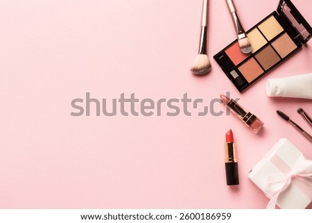 Make up products flat lay background on pink. Eyeshadow, highlighter, cream, lipsticks and cosmetic brushes.