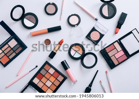 Make up products scattered on gray background, top view