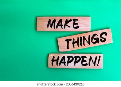 Make things happen! words made on wooden building blocks green background.