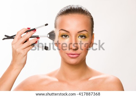 Make up. Brown sleek hair beautiful woman with fan brush close to face.
