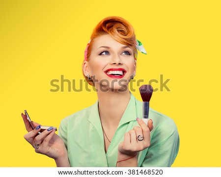 Make up. Close up portrait  headshot of Pinup retro style young woman pretty smiling girl teenager applying foundation powder, blusher with brush in green shirt holding mirror looking at you, camera