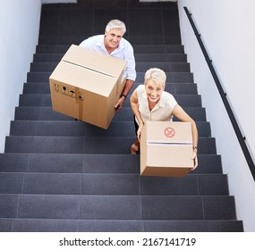 Make Way For Brand New Memories. Shot Of A Mature Couple Carrying Boxes Up The Stairs On Moving Day.