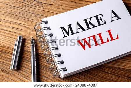 MAKE A WILL text on a notebook with pen on wooden background