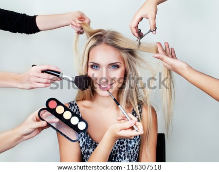 make up woman with many hands. makeup brushes, scissors, shadows.