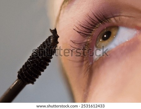 Make up your make-up. Putting mascara on eye-lid. 