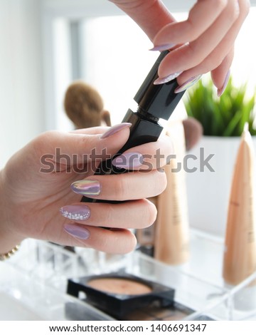 Make-up application with purple nails