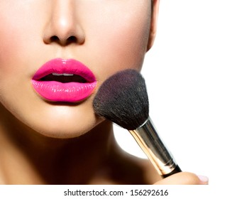 Makeup. Make-up Applying closeup. Cosmetic Powder Brush for Make up. Perfect Skin. Purple Lipstick. Isolated on a White Background. Makeover