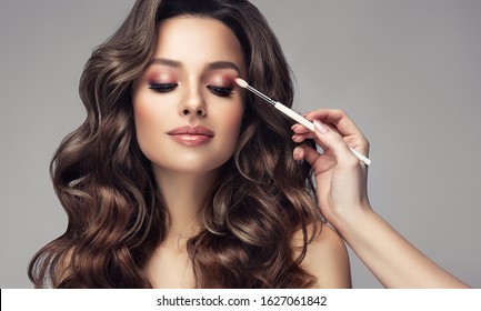  Makeup Artist Applies  Eye Shadow  . Beautiful Woman With Make-up Face. Hand Of Visagiste, Painting  Cosmetics Of Young Beauty  Model Girl . Make Up In Process