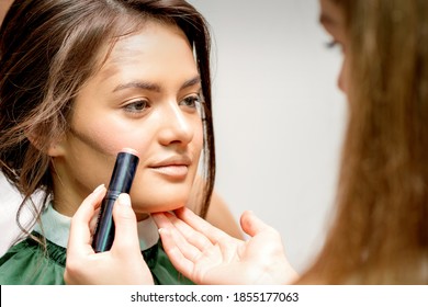 Makeup Artist Applying Cream Blush Stick Foundation On Cheek Of Young Caucasian Woman