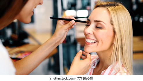 Makeup Artist Applying Liquid Tonal Foundation On The Face Of The Woman In Make Up Room