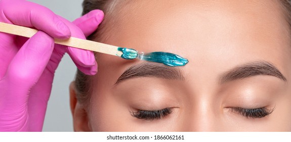 Makeup artist does facial hair removal procedure. Beautiful  teenage girl with blue eyes having Permanent Make-up Tattoo on her Eyebrows.  Professional makeup. - Shutterstock ID 1866062161