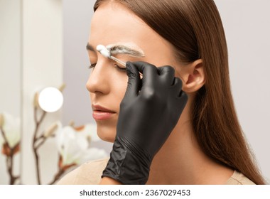 The make-up artist does Long-lasting styling of the eyebrows and will color the eyebrows. Eyebrow lamination. Professional make-up and face care. - Powered by Shutterstock