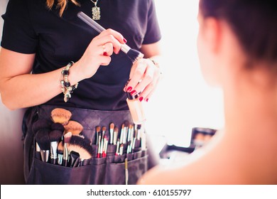 Makeup artist doing makeup for girl indoor - Shutterstock ID 610155797