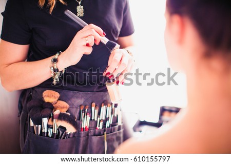 Makeup artist doing makeup for girl indoor