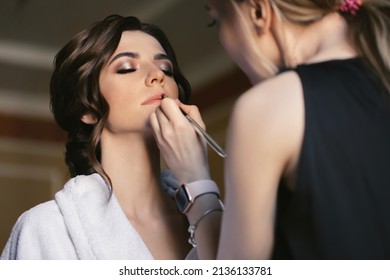 Make-up artist doing make up for young beautiful bride. Foto Stock