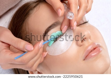 Make-up artist makes the procedure of lamination and dyeing of eyelashes to a beautiful woman in a beauty salon. Eyelash extensions. Eyelashes close-up Foto stock © 