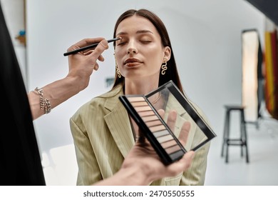 Makeup artist perfecting womans look. - Powered by Shutterstock