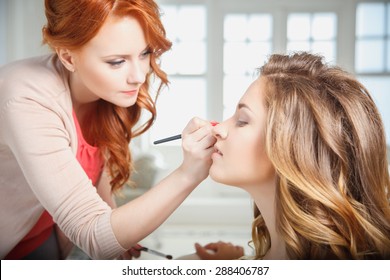 makeup artist preparing bride before the wedding in a morning - Shutterstock ID 288406787