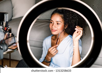 Makeup Artist Recording Video From Home. Woman Applying Cosmetics Sitting In Front Of Ring Light.