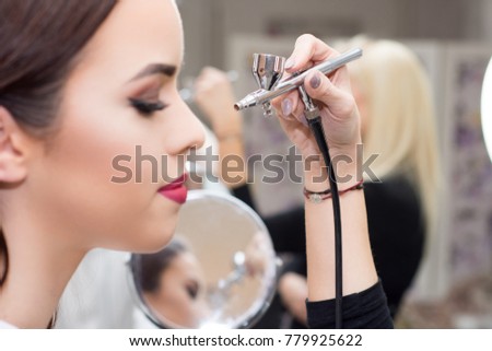 Makeup artist using airbrusher.