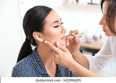 Makeup Artist Working With Asian Model In Beauty Salon