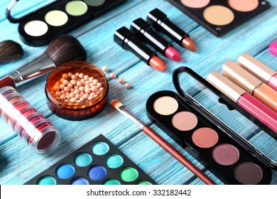 Makeup brush and cosmetics on blue wooden table - Shutterstock ID 332182442
