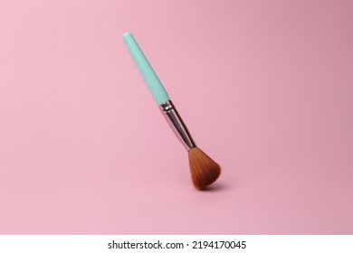 Makeup Brush Flying In Antigravity On Pink Background With Shadow. Levitation Object In The Air. Beauty And Fashion Concept. Creative Minimalist Layout