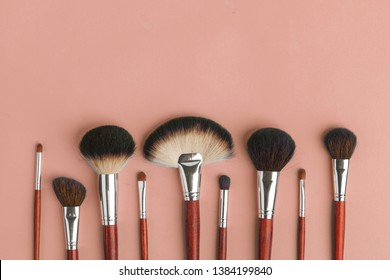 Makeup brush set, professional makeup tools, brushes for different functions on pink background