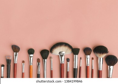 Makeup brush set, professional makeup tools, brushes for different functions on pink background