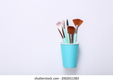 Makeup brushes in cardboard cup on white background - Powered by Shutterstock