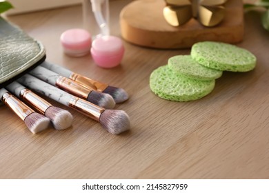 Makeup brushes and different cosmetic products on table, closeup