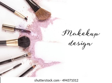 Makeup brushes, lip gloss and pencil on white background, with traces of powder and blush forming a frame. A horizontal template for a makeup artist's business card or flyer design, with copyspace