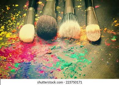 Makeup brushes on background with colorful powder. Make-up background  - Shutterstock ID 223750171