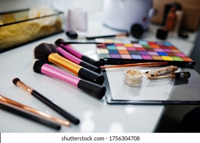 Makeup Brushes On White Gloss Table On Make Up Saloon.