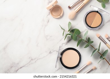 Make-up concept. Top view photo of makeup brushes contouring palette eyeshadow compact powder and eucalyptus on white marble background with empty space - Shutterstock ID 2154216321