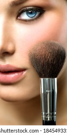 Makeup. Make-up Face. Big Make up brush. Makeup applying concept. Beautiful fashion model girl face closeup. Skin tone. Facial powder