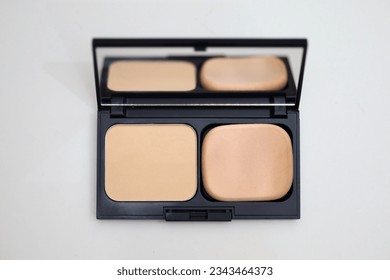 Makeup face powder isolated on white background, powder box and powder sponge complete with mirror