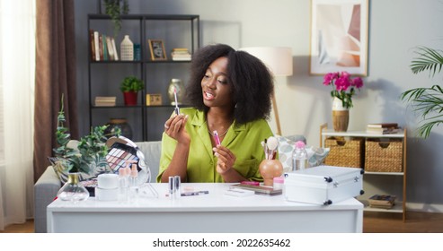 Makeup female vlogger creating cosmetic product explainer video. Portrait of African American woman recording personal make up vlog video. Young happy pretty influencer beauty fashion blogger - Powered by Shutterstock