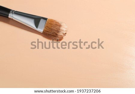 Makeup foundation background with beige liquid foundation, cosmetic makeup brush, Fluid foundation base for nude skin, copy space
