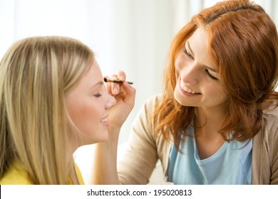 makeup, friendship and leisure concept - two smiling teenage girls applying make up at home - Shutterstock ID 195020813
