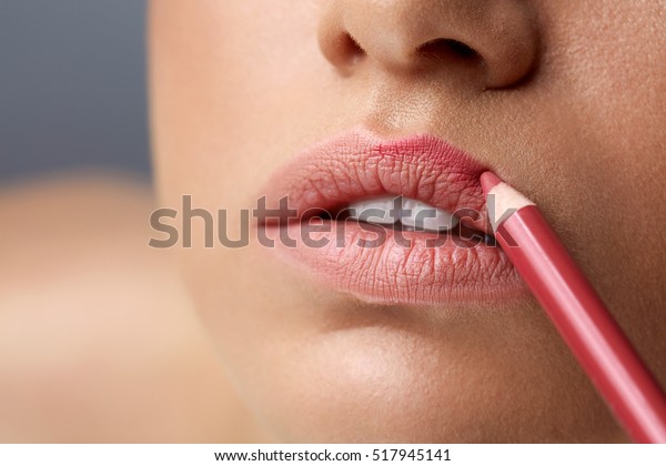 Makeup Lips. Closeup Of Beautiful Young Woman\
Applies Color Contour Lip Pen, Lip Liner. Girl Contouring Sexy Full\
Lips With Lip Pencil, Beauty Product. Cosmetics Concept. High\
Resolution Image