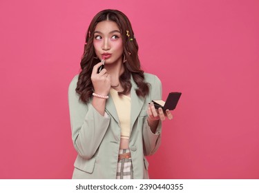 Makeup lipstick woman ready looking in pocket mirror. beautiful trendy young asian female fashion model putting makeup on pink background. - Powered by Shutterstock