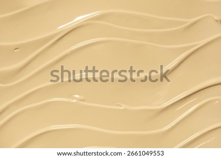 Makeup liquid foundation medium color tone smudge blur cream background. Cosmetic beauty product sample swatch