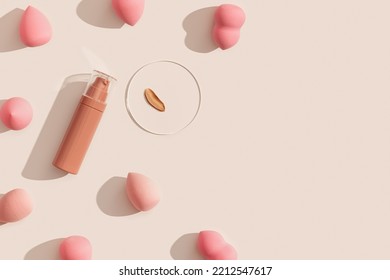 Makeup Liquid Foundation Nude Cream Cosmetic Bottle, Cosmetic Swatches On Glass Disk, Beauty Blender, Sponges, Make Up Puff On Beige Background With Dark Shadows And Copy Space. Tonal Bb Cream