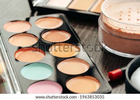 Make-up palette with colorful concealers on gray background