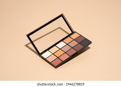 Make-up palette floating over a beige background. Professional multicolor eye shadow make-up palette. Cosmetic products - Shutterstock ID 1946278819