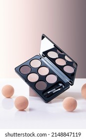 Make-up palette floating over a beige background. Professional basic eye shadow make-up palette.