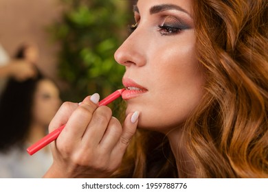 Makeup preparation process. Professional Makeup artist works on model face in beauty studio. Backstage. Applying lip liner to the lips. - Powered by Shutterstock